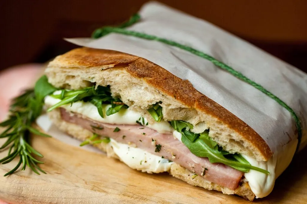 Ciabatta med skinka, mozzarella och ruccola inslagen i papper och knuten med snöre