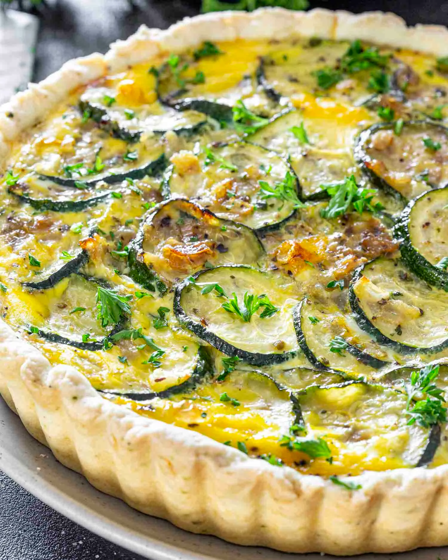 Nybakad paj med skivad zucchini, ägg och persilja